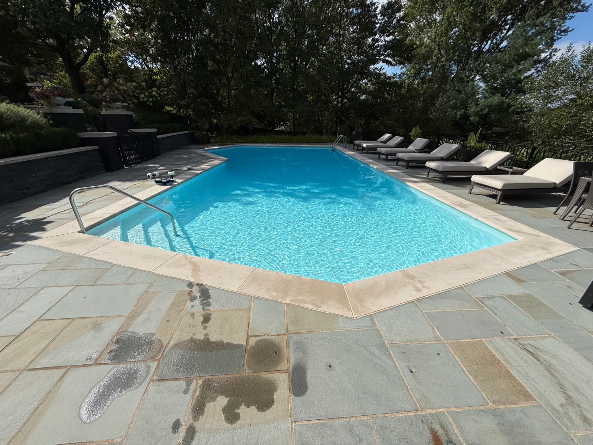 Residential pool with bright blue water and stone patio